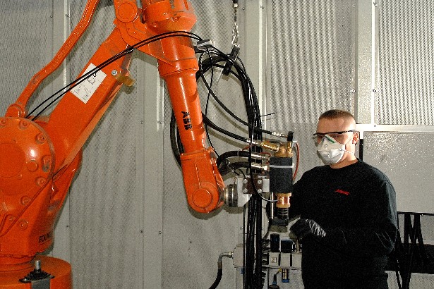一位当地的制造业员工在Turbocoating公司操作机器人设备.