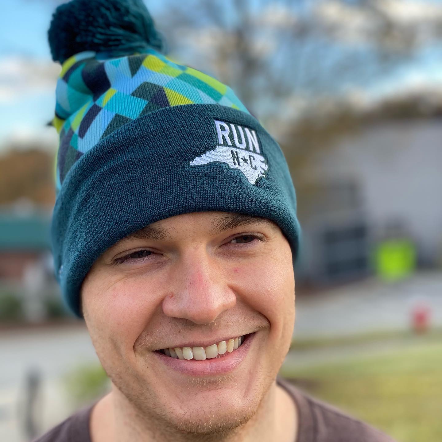 white man in winter beanie hat with "run nc"