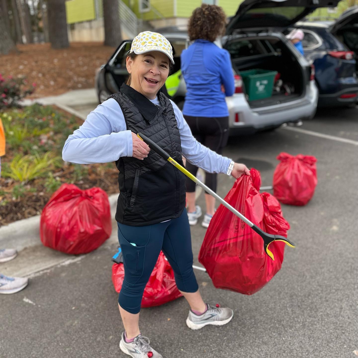 woman holding  trash bag and grabber