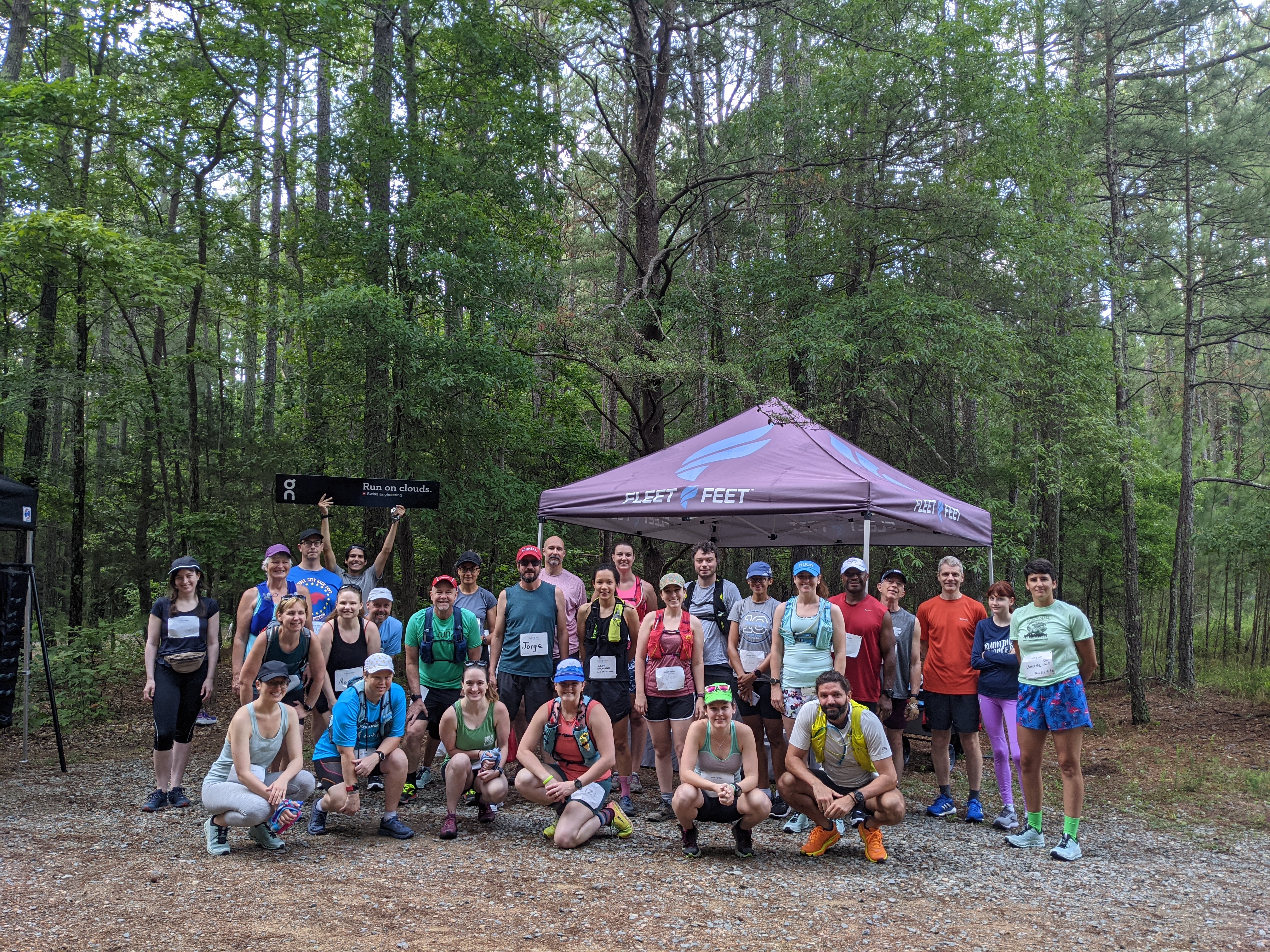 trail running group in front of a Fleet Feet tent in the woods!