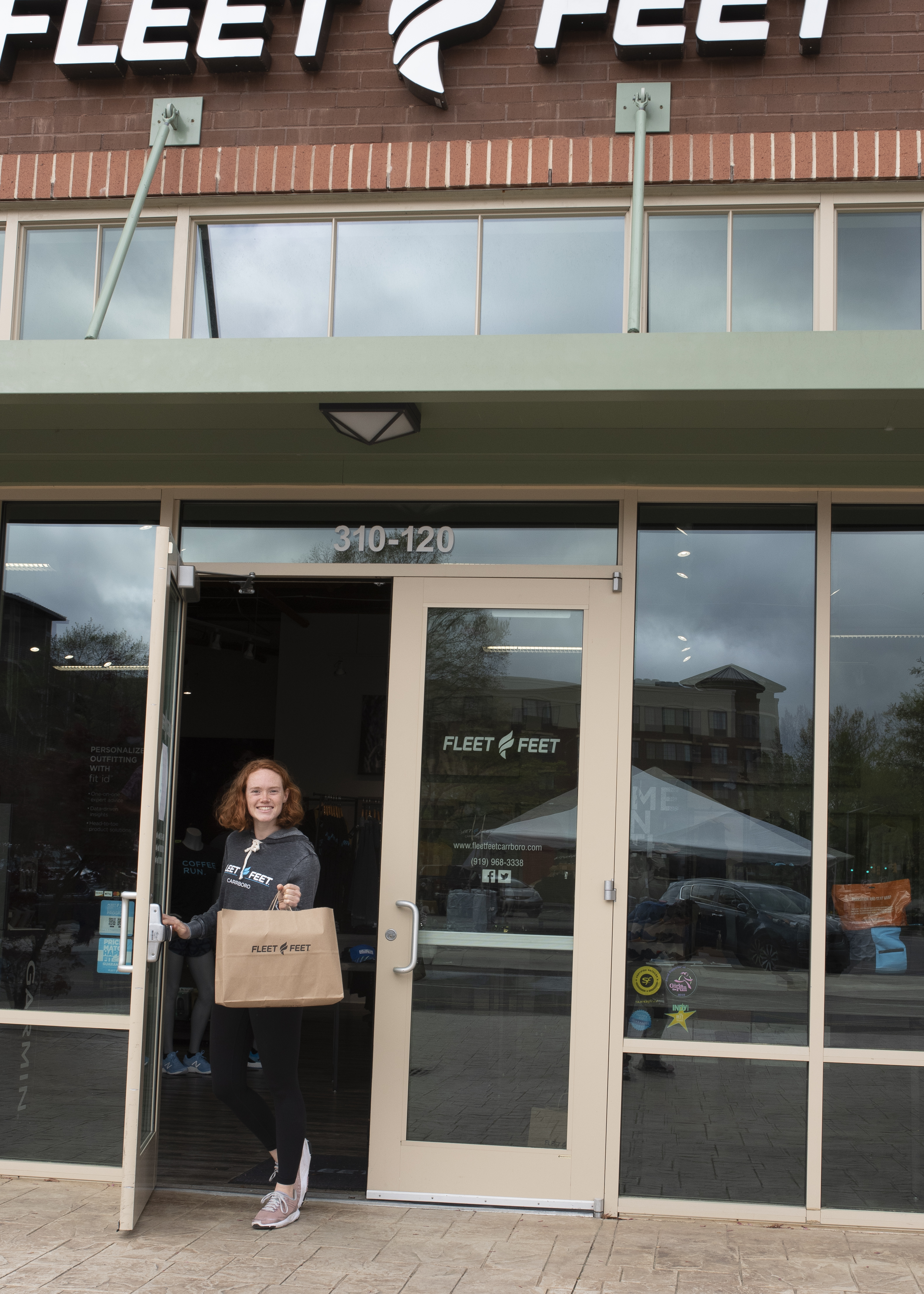 Woman bringing shopping bag outside the Fleet Feet store.