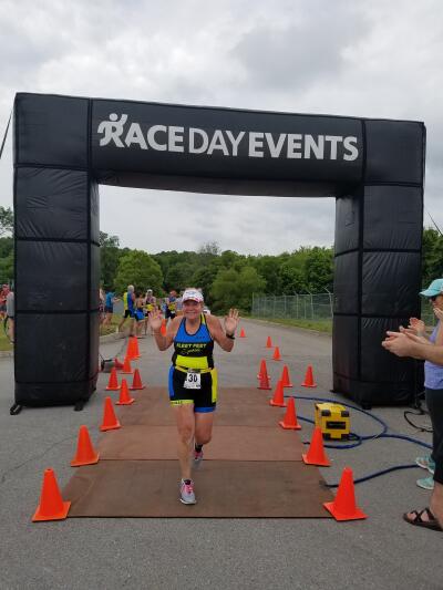 Susan crossing the finish line at Foothills