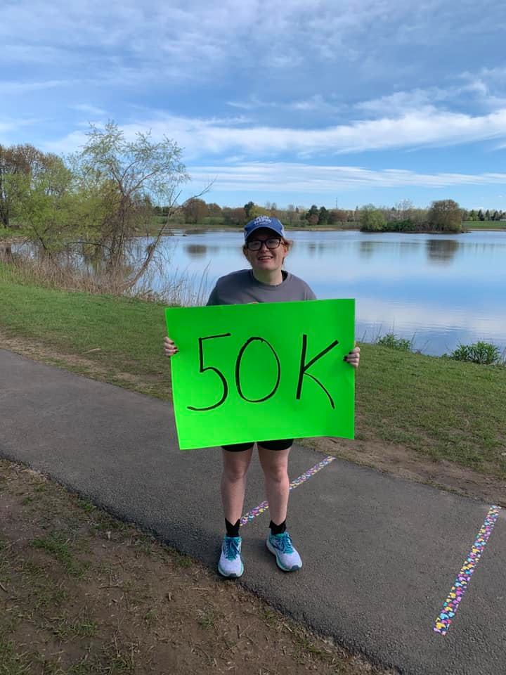 Gracie Holding a 50K ultramarathon Sign