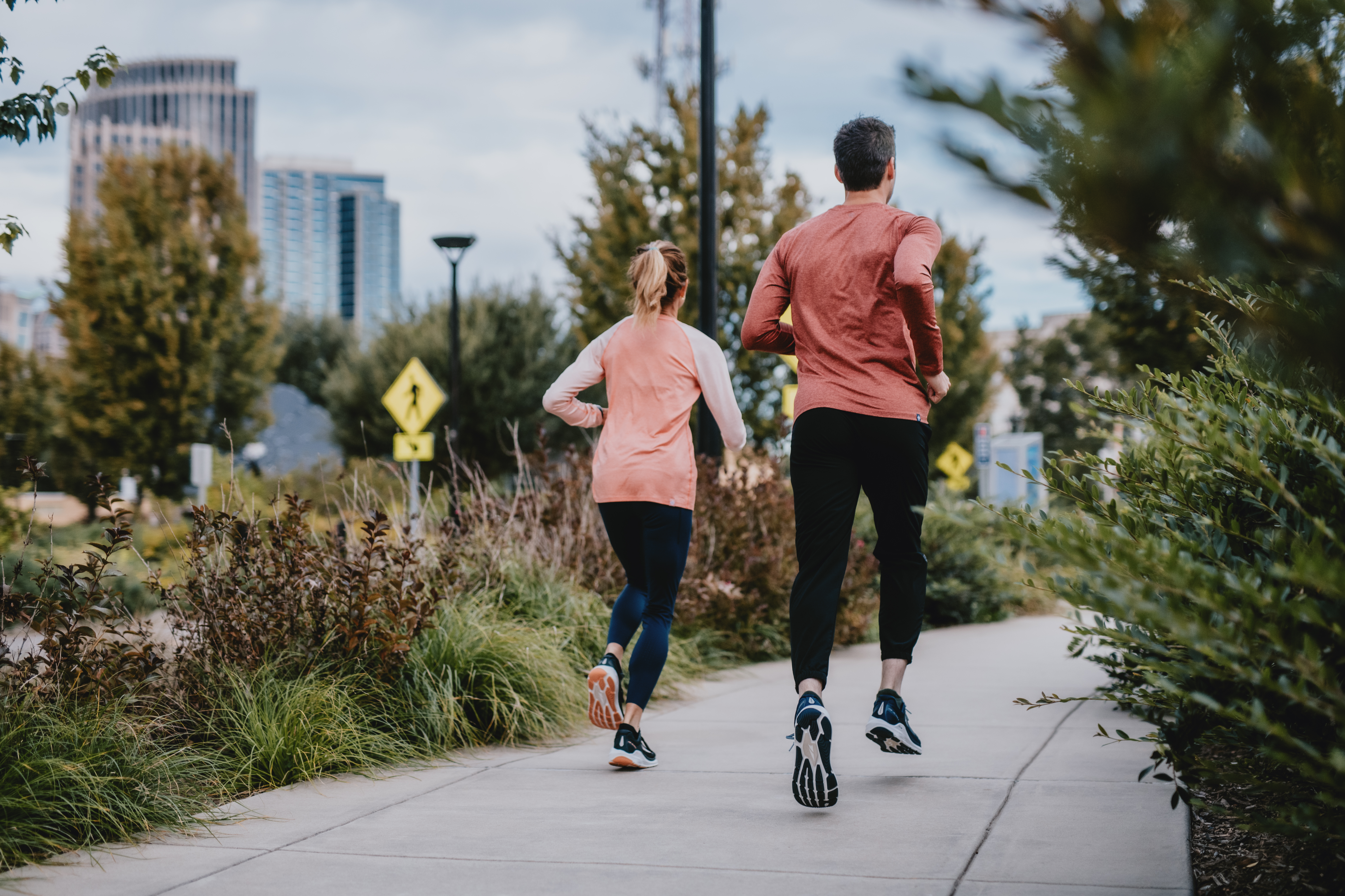 Two people going for a run on a paved path