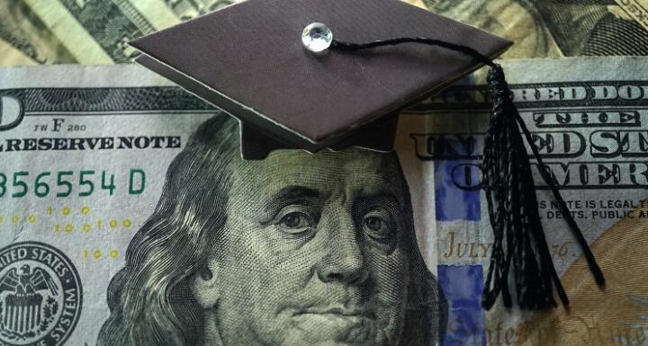 $100 dollar bill with graduation cap