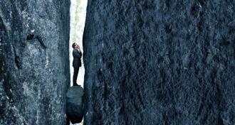A business man stuck between a rock and hard place