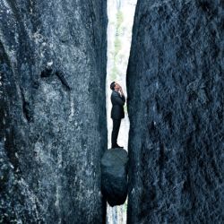 a businessman stuck between two rocks