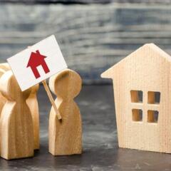 A crowd of people with a poster standing near the house