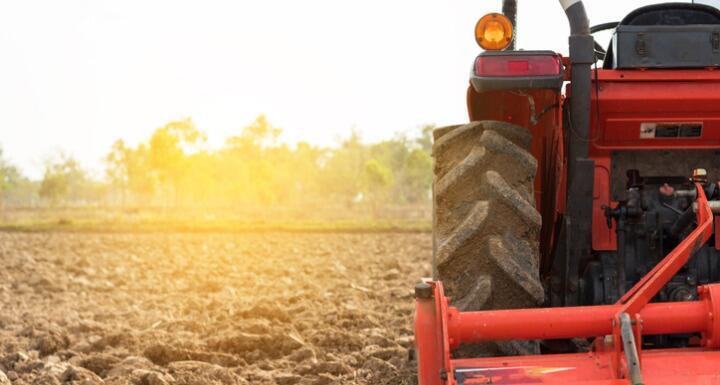 Red Tractor plowing field