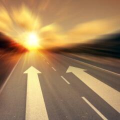 Arrows on a road leading to the sun