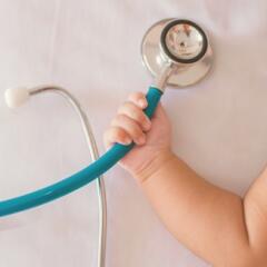 A baby's hand holding a stethoscope