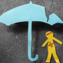 bandaged paper man under cracked umbrella