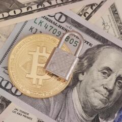 Lock and bitcoin on top of paper money