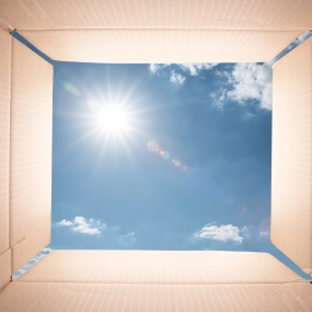 opened cardboard box with sky in background