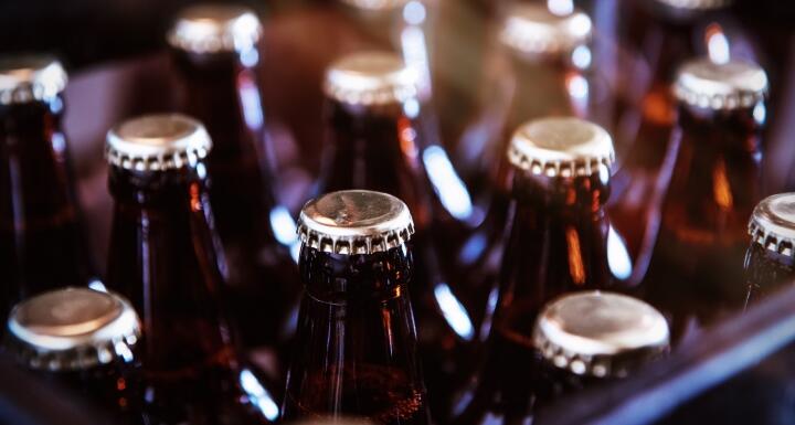 Close up of beer bottles and unbranded silver beer caps