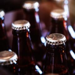 Close up of beer bottles and unbranded silver beer caps