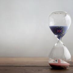 Hour glass sitting on a table with sand half way empty