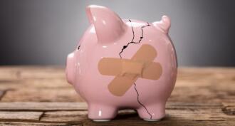 broken piggy bank with bandaid on crack