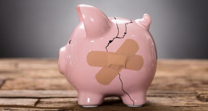 broken piggy bank with bandaid on crack