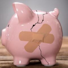 broken piggy bank with bandaid on crack