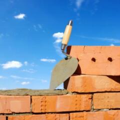 A brick wall being built with blue skies in background