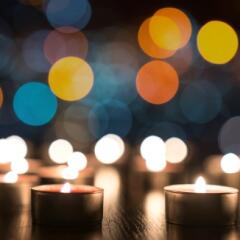Several small lighted memorial candles on a darks background