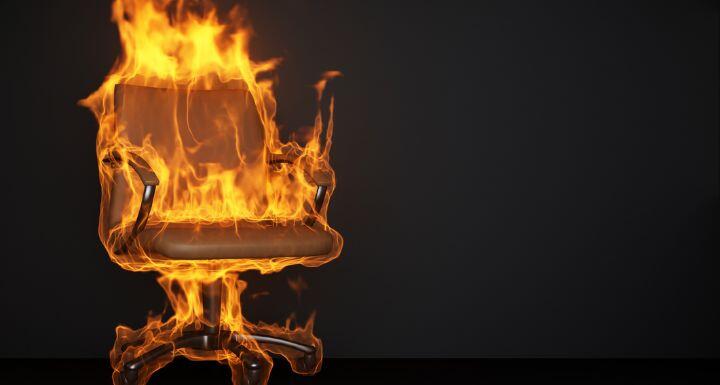 Burning office chair on black background