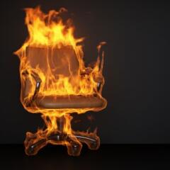 Burning office chair on black background