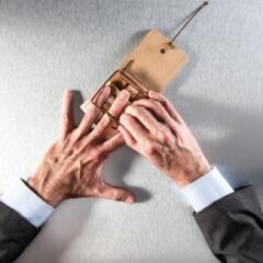 Businessman's hand in a mouse trap