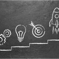 a chalk board with business symbols and a rising graph line