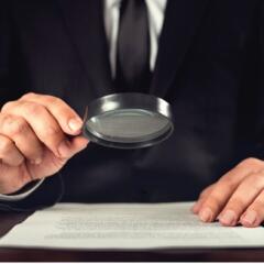 Businessman reading contract with magnifying glass