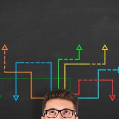 A man in front of a blackboard with chalk diagrams above his head