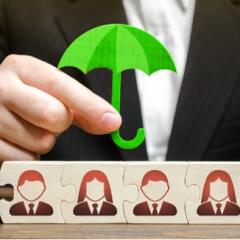 Businessman holding umbrella over puzzle pieces with business people avatars