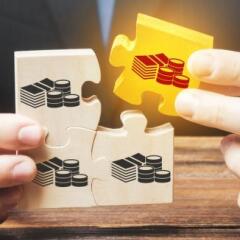 Businessman holds the wooden puzzle with a picture of money
