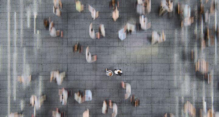 Businessman standing in the fast moving crowds