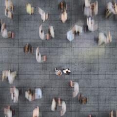 Businessman standing in the fast moving crowds