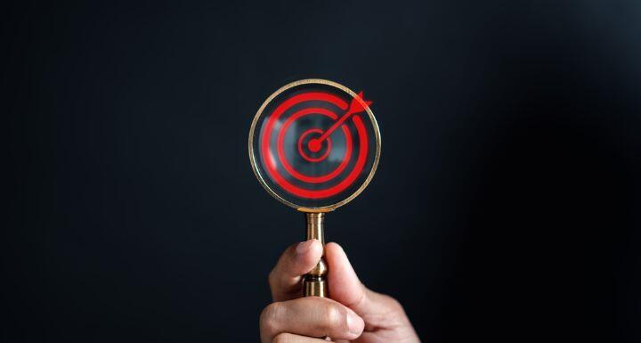 Businessman using magnifying glass focus to target icon
