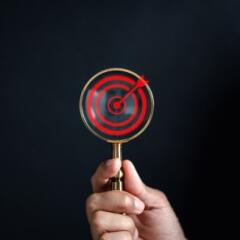 Businessman using magnifying glass focus to target icon