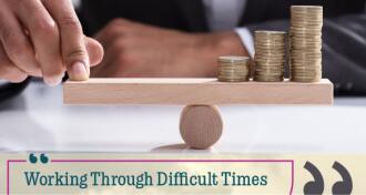 Businessperson Balancing Stacked Coins On Wooden Seesaw