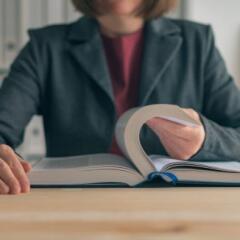 Businesswoman reading book at office desk