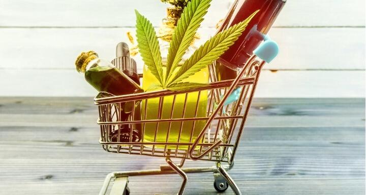 CBD goods including a leaf bar of soap and bottles of oil in a metal shopping cart