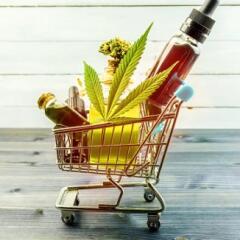 CBD goods including a leaf bar of soap and bottles of oil in a metal shopping cart