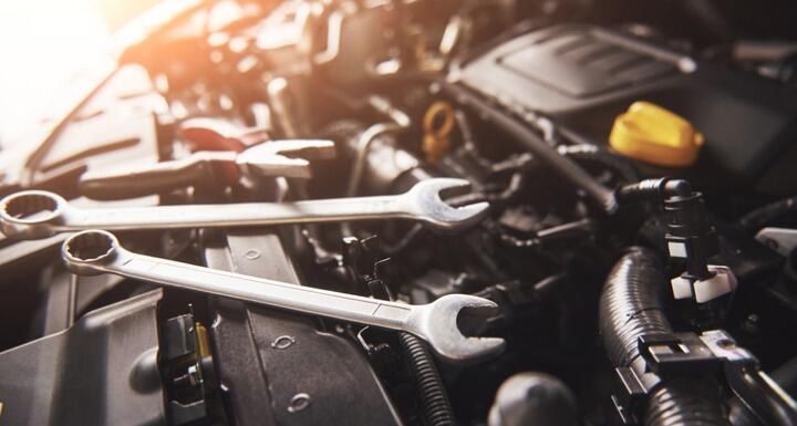 View of underneath a car hood with tools