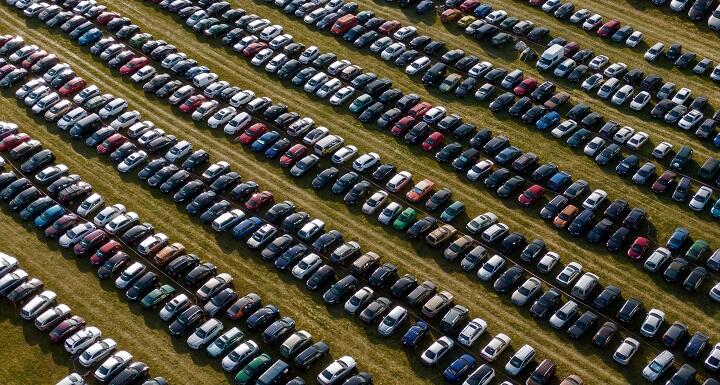 Many cars parked in a field