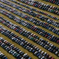 Many cars parked in a field