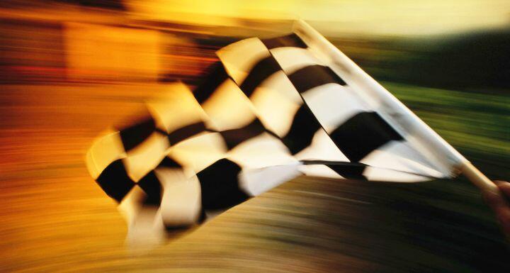 Checkered flag waving at an car race.