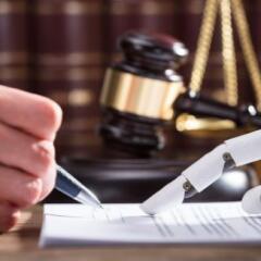 Close up of robotic hand assisting person filling forms with gavel and justice scales in background