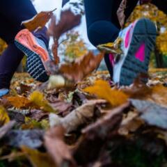 close up of two sole of shoes running through park