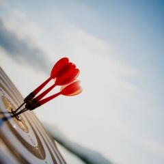 Close up shot red darts arrows in the target center