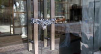 Closed glass door with metal chain and lock around handles